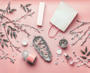 Wall Mural - cosmetic concept. various facial products and paper shopping bag on pastel pink background with cher
