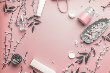 Wall Mural - cosmetic concept. facial skin care products and paper shopping bag on pastel pink background with ch
