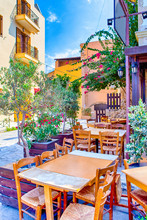 Sunny Open Air Cafe In Chania City On Crete. With Flowers And Olive Trees All Round In Crete, Greece.