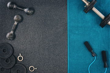 Fitness or bodybuilding concept background. Product photograph of old iron dumbbells on black grey, conrete floor in the gym. Photograph taken from above, top view with lots of copy space