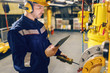 © dusanpetkovic1 - Close up of worker in protective suit using tablet and pressing button while standing in heat plant.