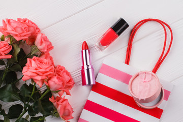 Red female belongings. Accessories for makeup and shopping. White wooden background.