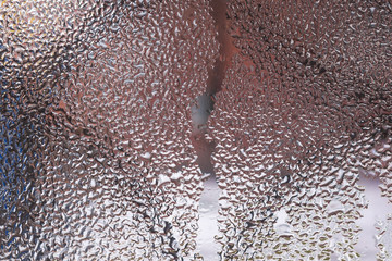 Water drops on glass window close up with blurred background. Drops in macro. Condensate on window closeup. Wet air.