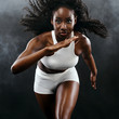 © Mike Orlov - Strong athletic black skin woman sprinter, running on background with smoke wearing in the sportswear. Fitness and sport motivation. Runner concept with copy space.