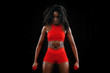 © Mike Orlov - Sporty fit black skin woman in red sportswear, athlete with dumbbells makes fitness exercising on dark background.