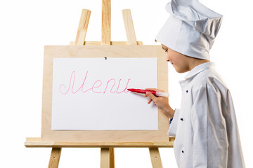 Wall Mural - cute boy in chef uniform preparing menu on paper on white background