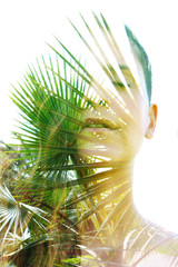 Wall Mural - Double exposure close up of a young happy natural beauty and bright shining tropical leaves