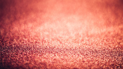 Abstract shiny coral color texture with bokeh blur.