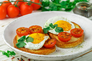 Wall Mural - Bruschetta with fried egg, tomatoes and herbs. Delicious breakfast. Selective focus