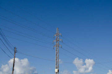 power tower transmission line over the blue sky with white clouds