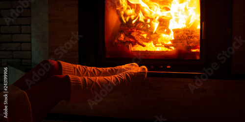 Fotografía A woman in knitted socks is sitting near the fireplace on a cold winter evening