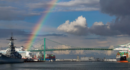 A rainbow over the Port of Los Angeles main channel, Battleship Iowa, a cruise ship, container port operations and Vincent Thomas suspension bridge