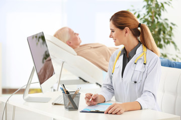 Canvas Print - Professional doctor with mature patient in hospital