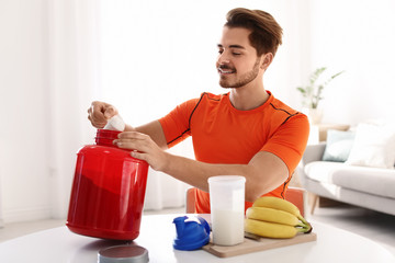 Sticker - Young man preparing protein shake at table in room