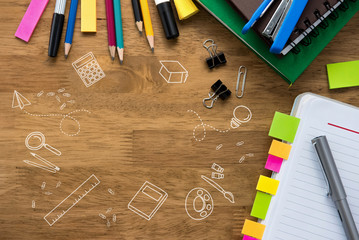 Colorful stationery on wooden table background with doodle drawings