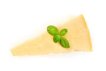 A piece of aged Parmesan cheese with fresh basil leaves, shot from the top on a white background with copy space