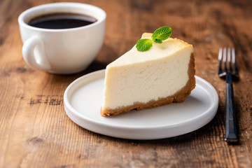 Cheesecake and cup of coffee on wooden table. Coffee and cake. Horizontal view