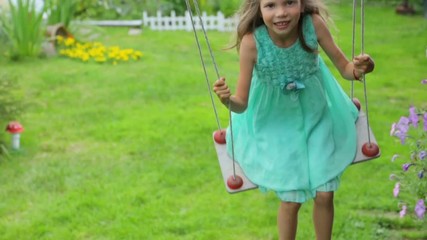 little girl swinging in garden