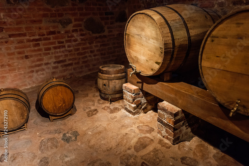 Fotografie, Obraz Wine barrels stacked in the old cellar of the winery