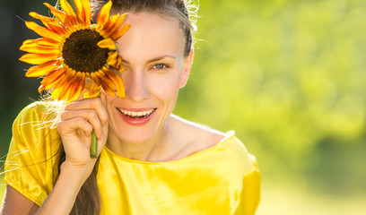 Beautiful woman in spring garden with flowers on her eyes. Summer fun concept 