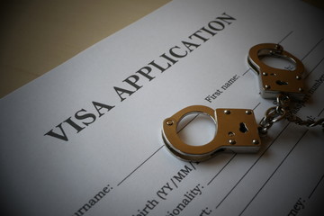 Visa application form with handcuffs, Illustration for misuse of fake Visa