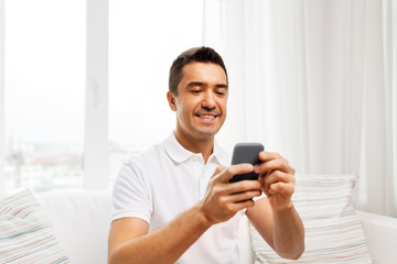 Poster - technology, people and communication concept - happy man with smartphone at home