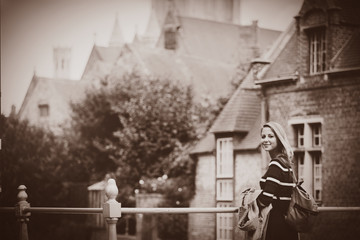 Wall Mural - young girl in red sweater at streets of Bruges. Belgium, Atumn season Image in sepia color style