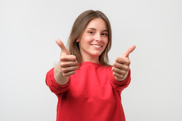 happy smiling beautiful young woman showing thumbs up gesture
