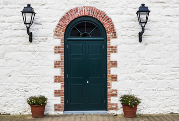 Old vintage brick arched doorway on vintage stone wall house.