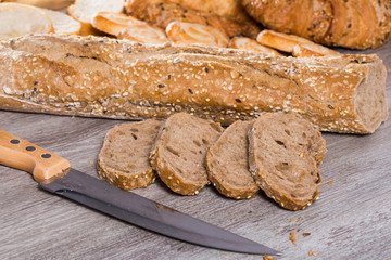 slices of wheaten bread and knife on wooden surface