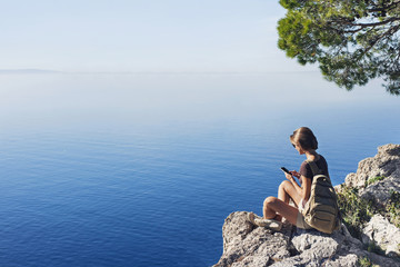 Wall Mural - Hiking woman using smart phone. Vacations, summer fun, enjoy life, travel and active lifestyle concept.