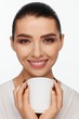 © Andriy Goncharenko - Portrait of a smiling beautiful woman with collected hair and a white mug in her hands