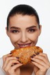 © Andriy Goncharenko - Portrait of a smiling beautiful woman with a sesame bun in her hand