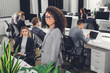 © LIGHTFIELD STUDIOS - beautiful young african american businesswoman in eyeglasses looking at camera in open space office