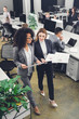 © LIGHTFIELD STUDIOS - high angle view of professional young businesswomen holding papers and discussing project in office