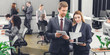 © LIGHTFIELD STUDIOS - professional young business colleagues discussing papers while standing together in open space office