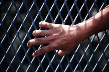 close up of hand in jail background.