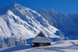 tatrzański zimowy pejzaż z zaśnieżoną chatką w Dolinie Gąsienicowej