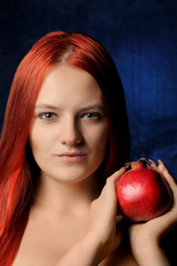 Wall Mural - portrait of beautiful girl with red hair and pomegranate fruit on the background of blue wall. different poses.