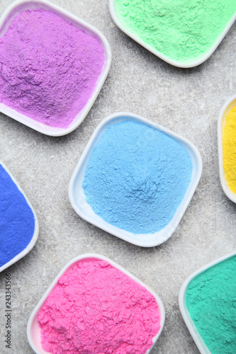 Fotografia Colorful holi powder in bowls on grey background