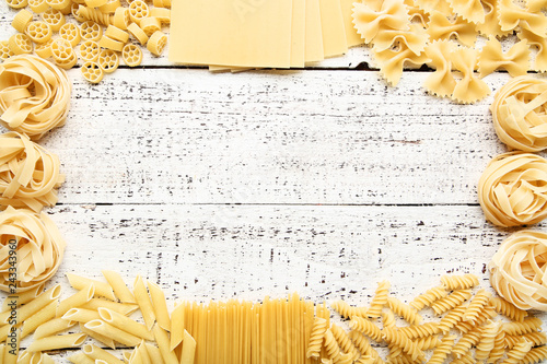 Fotografía Different uncooked pasta on white wooden table