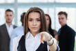 © opolja - Businesswoman pointing her finger at you on the background of business people.