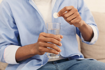 Wall Mural - Man holding soluble white pill and a glass of water