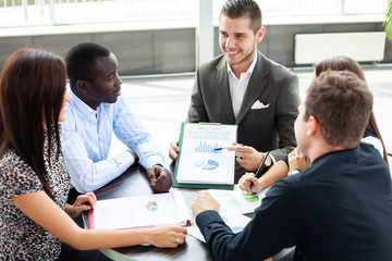 Canvas Print - Image of business partners discussing documents and ideas at meeting.