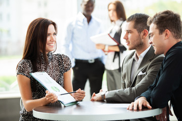 Canvas Print - Image of business partners discussing documents and ideas at meeting.