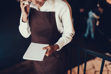 Wall Mural - Glad woman with notepad speaking on telephone