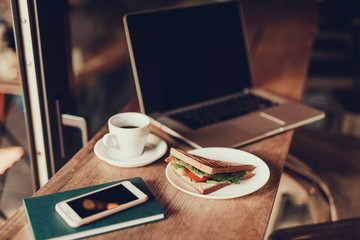 Group of gadgets and lunch on table in cafe