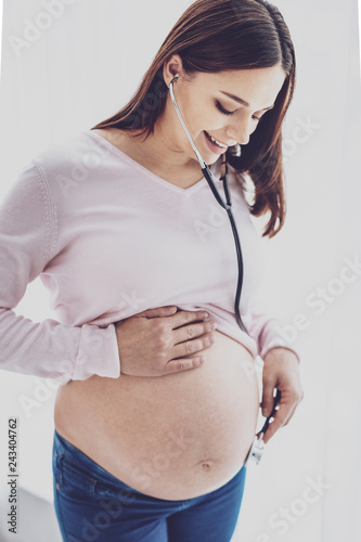 Fotografie, Obraz Pretty pregnant woman listening to babys heartbeat