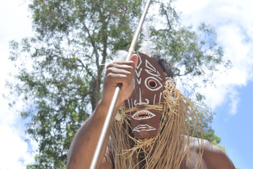 Unrecognizable Torres Strait Islander man dancing traditional dance in Torres Strait Islands near Australia's Cape York Peninsula and the island of New Guinea.