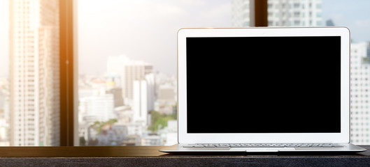 Computer, laptop with blank screen on wood table with office window view backgrounds.